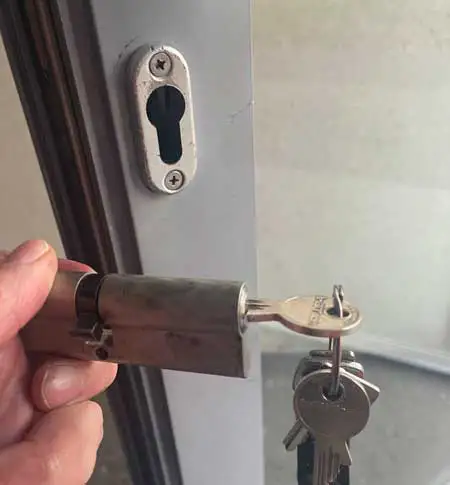 Schlosswechsel Hannover: ausgebauter Profilzylinder mit Schlüsseln in der Hand des Monteurs – Schlüsselnotdienst vor Ort